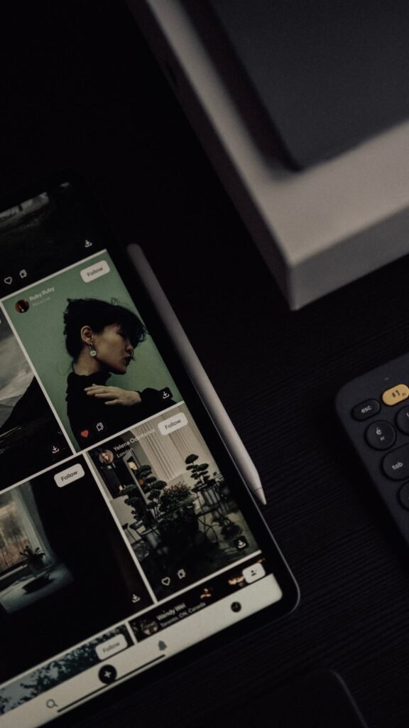 Tablet displaying a curated social content feed beside a stylus and keyboard
