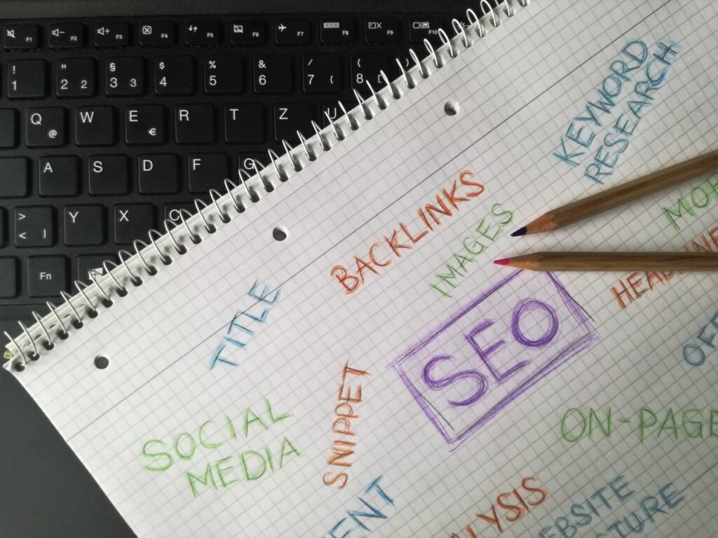 Notebook with an SEO strategy sketch: keywords, backlinks, on-page and social media