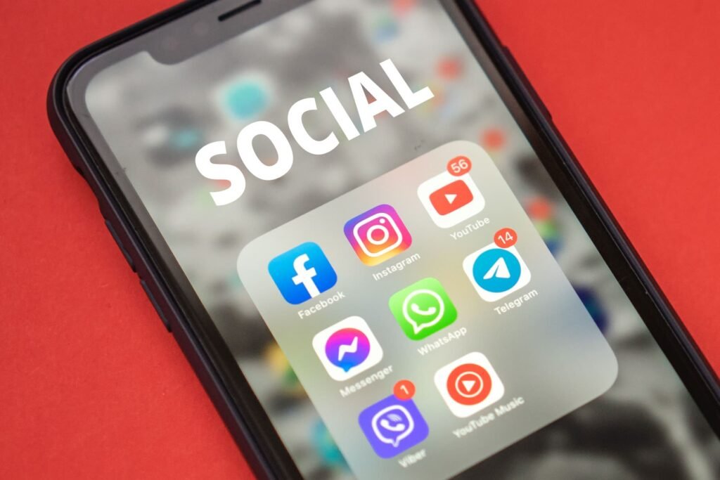 Smartphone showing a folder of social media apps including Facebook, Instagram and YouTube